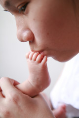 Obraz na płótnie Canvas mother kiss baby's foot