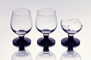 Three wineglasses including a broken one