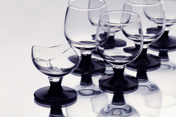 Some wineglasses with a broken one