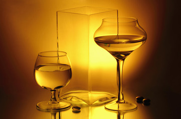 Two wineglasses and a vase on the mirror