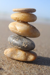 Fototapeta na wymiar Five stones pyramid near the sea