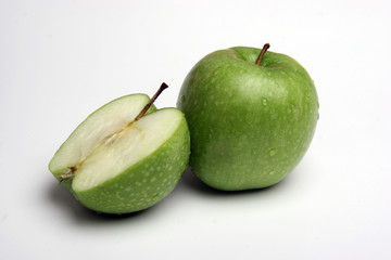 Grüner und geschnittener Apfel auf weißem Hintergrund