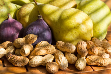 still life of fresh and fragrant peanuts, red figs, green pears