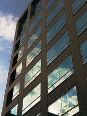 ビルの窓に反射する夕空と雲