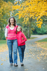 Cute girl with her mother walking in park