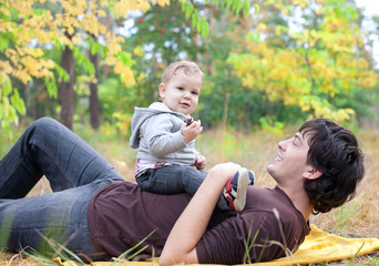 Naklejka na ściany i meble dad playing with son on autumn outdoor