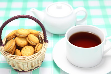 籠に入れたクッキーサンドと紅茶