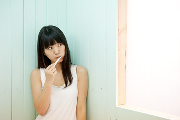Naklejka premium pretty asian woman brushing her teeth