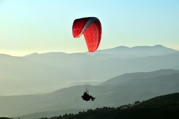 The paraglider pilot flying over mountains