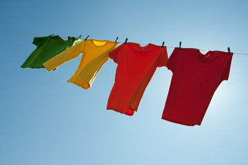 Colorful clothes hanging to dry in the blue sky
