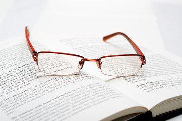 Reading glasses lying on the open book
