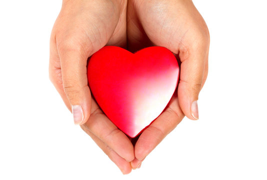 Female hands taking care of red heart