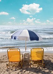 Two loungers under sun umbrella at the beach
