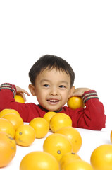 Fototapeta na wymiar Funny child with many oranges isolated on white background