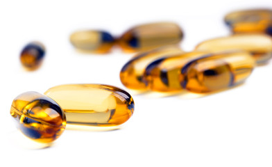 Fish oil capsules in shallow focus isolated on a white background