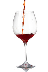 Red wine pouring into glass isolated on white