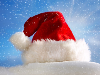 Santa Claus hat on snow in front of blue sky