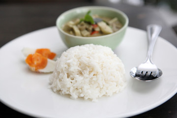 Thai food chicken green curry with rice in wood background