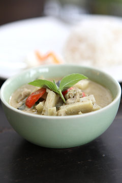 Thai food chicken green curry with rice in wood background