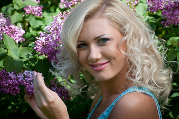 Naklejka premium Young blonde woman in the park