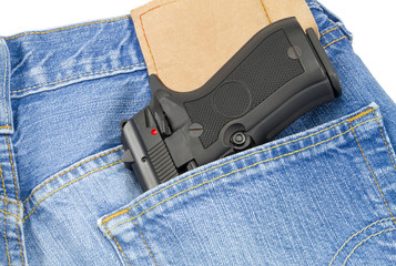 Hand fire arm weapon in blue jeans back pocket