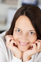 lachende frau stützt kopf auf