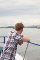 Fototapeta premium tourist costs on a deck of the steam-ship and looks at coast