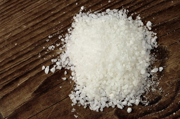 Coarse sea salt on a wooden table