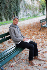 Fototapeta premium Man writing on Netbook on a Bench Outdoors