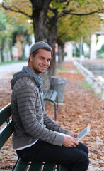 Fototapeta premium Man sitting on a Bench with netbook smiling
