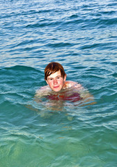 boy enjoys the beautiful water of the ocean