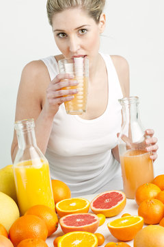portrait of young woman with citrus fruit and orange juice