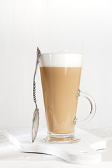 coffee latte with frothy milk in tall glass