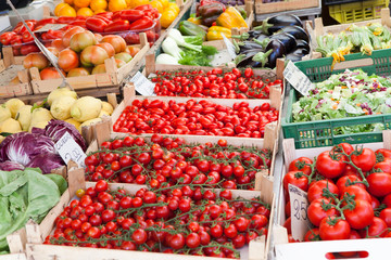 Fresh raw vegetables in wooden boxes at open street market close