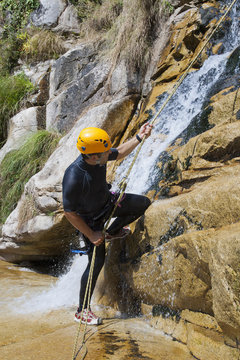 Men descending waterfall