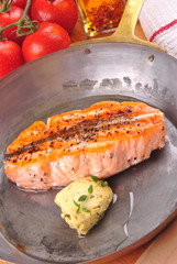 gegrilltes Lachssteak mit Kräuterbutter in einer Messingpfanne