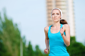 Beautiful woman running in green park