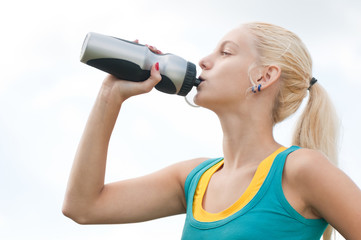 Woman drinking water after exercise