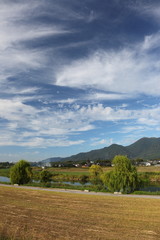 川原の牧草地と川と山と空