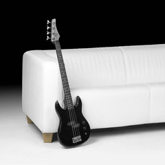 black bass guitar and white couch