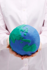 粘土の地球儀を持つ女性