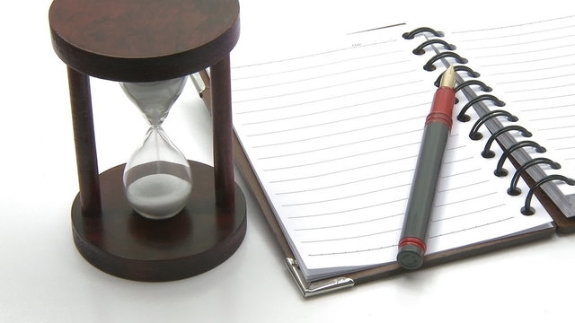 Hourglass pen notebook time concept