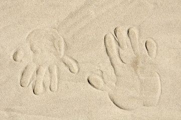 Fototapeta na wymiar sand background with big and small palm print