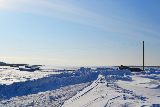 Coast of frozen Onega lake, sunny winter day.