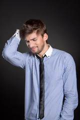 Young business man headache over gray background