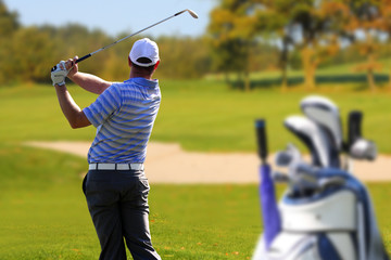 Man playing golf with golf bag