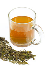 tea in glass cup and dried leaves