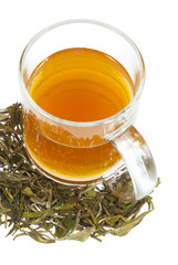 tea in glass cup and dried leaves