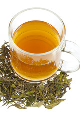 tea in glass cup and dried leaves