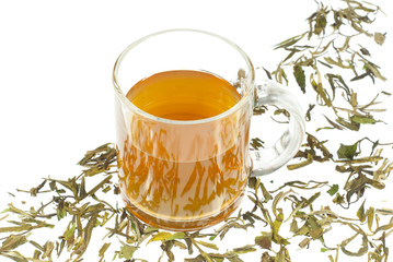 tea in glass cup and dried leaves